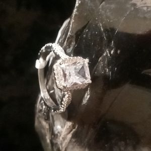 Princess cut simulated diamond engagement ring with pave diamond twisted band.